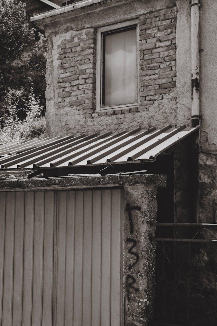 Weathered residential garage door on a brick house